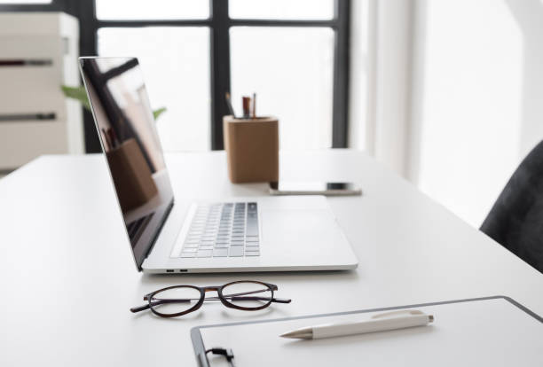 istock Place of work in office, laptop computer, glasses at office desk 1690512280