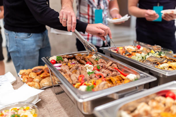 istock People choosing fresh prepared food from buffet table. 1690568100