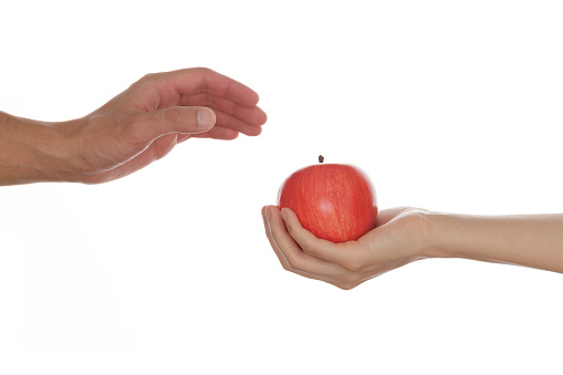 Woman Giving Apple to Man on White Background. Isolated on White. Cut out.