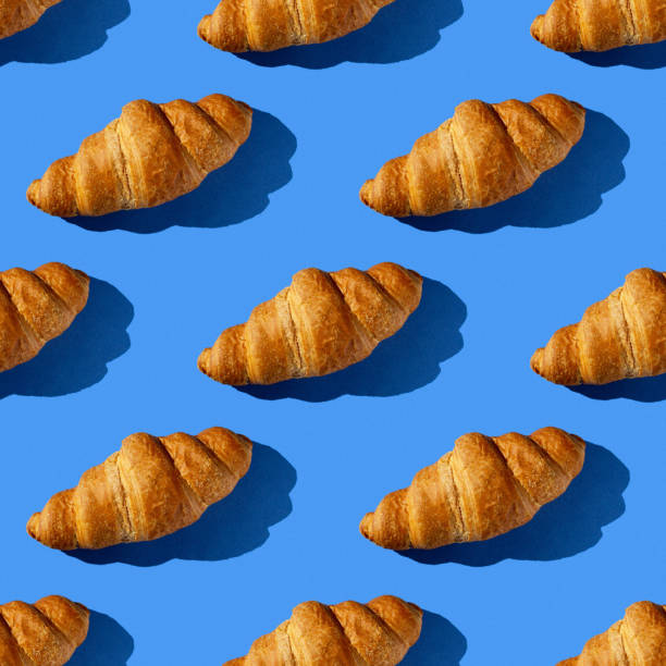 istock seamless pattern of croissant on a blue background with hard light 1690593803