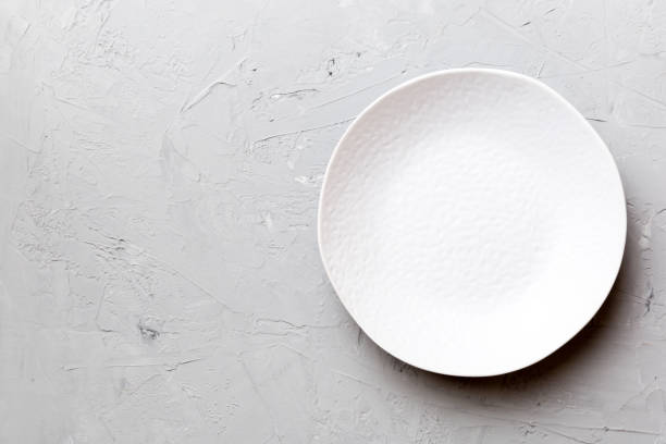 istock Top view of empty light plate on cement background. Empty space for your design 1690597159