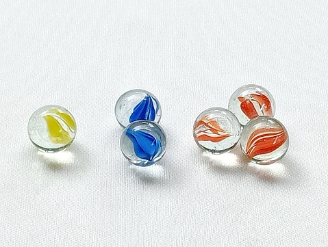 Marbles are children's toys from the 90s. Many marbles on a white background.