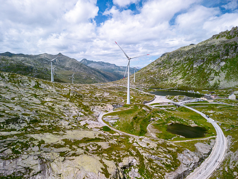 alpine wind turbines at an altitude of 2000 meters, turbines against the backdrop of mountains, ecology, wind energy, smooth shooting from a drone 4K