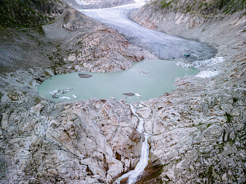 A lake formed as a result of the melting of a glacier in Rhonegletscher Switzerland, water from the glacier enters the lake after a large stream falls from a cliff
