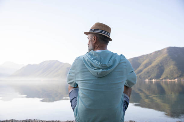istock A middle-aged man sits on the seashore with his back turned 1690662170