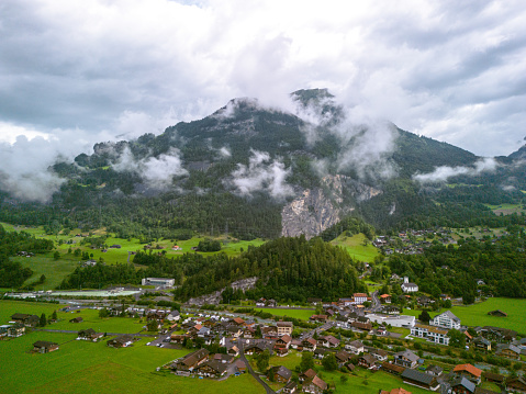 Aerial view of beautiful Swiss nature and village in Switzerland, with clouds in the mountains