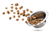 Dry cat food flies out of a bowl on a white background. Isolated