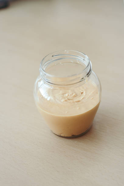 istock Homemade peanut butter in a glass jar. Selective focus. Process 1690681007