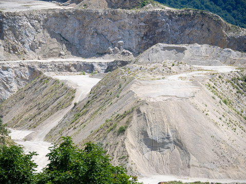 Conveyor belt, an excavator and a pile of gravel. Open-pit mining. No people.