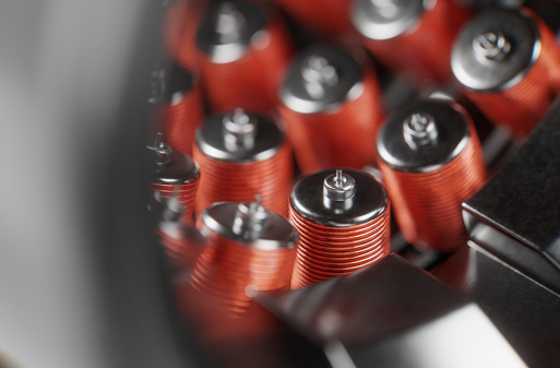 A conceptual electric car motor on dark gradient background, created in 3D. Close up of copper and steel parts inside the electric engine.
