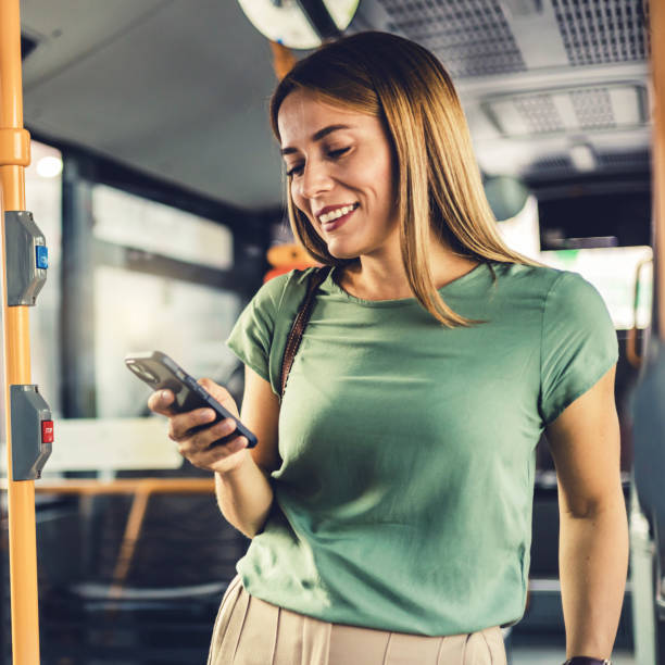 대중교통으로 출퇴근하는 동안 휴대전화를 사용하는 매력적인 여성 승객. - bus commuter passenger mobile phone 뉴스 사진 이미지