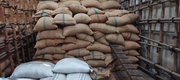 pile of jute sacks in an industrial area warehouse, during the day in Indonesia.  burlap sack filled with dried cloves.  September 2023