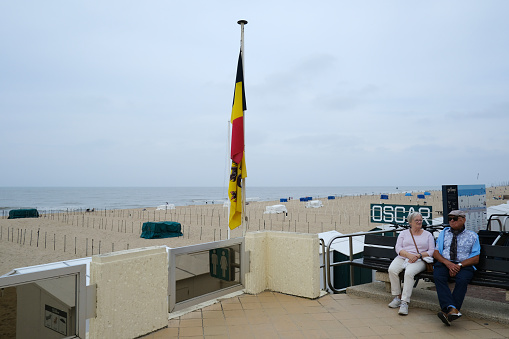 Elderly people enjoy the view of sandy beach of De Haan, Belgium on September 17, 2023.