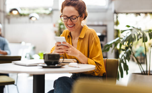 istock Happy postgrad student reading a text message her phone in a coffee shop 1690799291