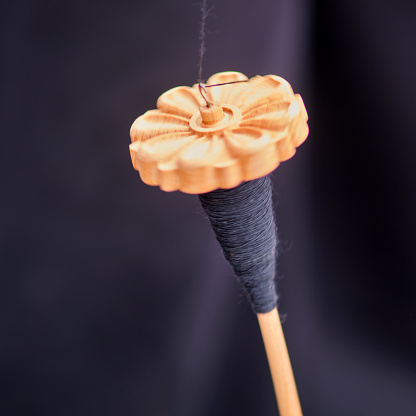 The vintage wooden spindle is a valuable tool for hand spinning and sewing enthusiasts.