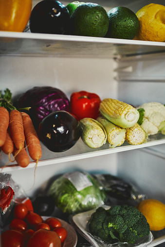 An image of a refrigerator stocked up with fresh vegetables, raw and organic food, stock photo