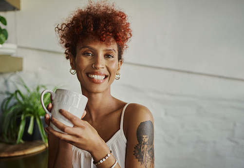 Beautiful vibrant young black woman enjoying a hot beverage, stock photo, copy space
