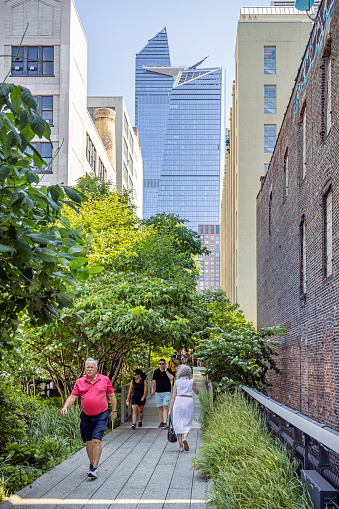High Line Park, Manhattan, New York, USA - August 9th 2023:  People walking in the famous elevated park between the new skyscrapers at Hudson Yard