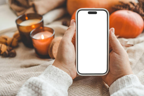 Phone with an isolated screen in hands, autumn mood