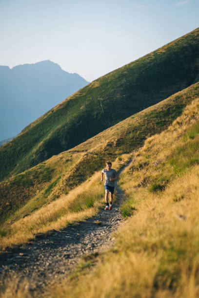 istock Trail runner bounds along mountain trail 1690850378