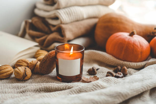 istock Burning candle with label isolated in autumn interior 1690850914