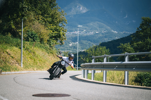 He is banking on a curving road in the mountains, Ticino Canton