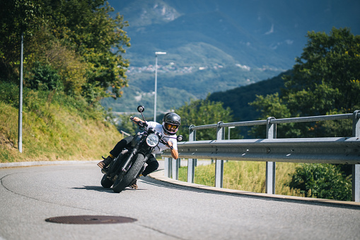 He is banking on a curving road in the mountains, Ticino Canton