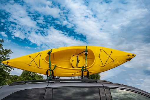 Roof mounted kayak on top of a van for transportation . High quality photo
