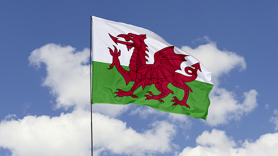 3d illustration flag of Wales. Wales flag isolated on the blue sky.