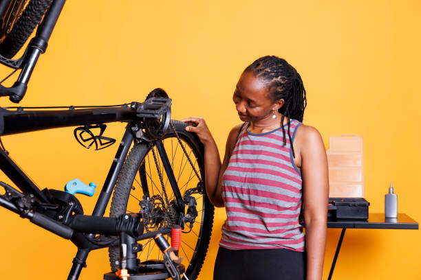 istock Black woman checking bicycle tire 1690873869
