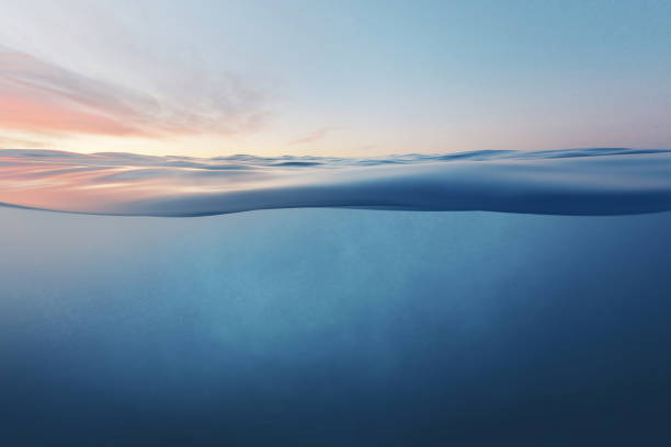 Blue sea or ocean water surface and underwater against sunset.