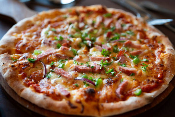 istock Pizza with Mozzarella cheese, onion, tuna fish, tomato sauce, pepper, basil. Italian pizza on wooden table background 1690899421