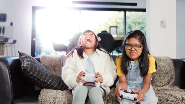 Dynamic Duo: Sisters Immersed in Exciting Video Game Adventure