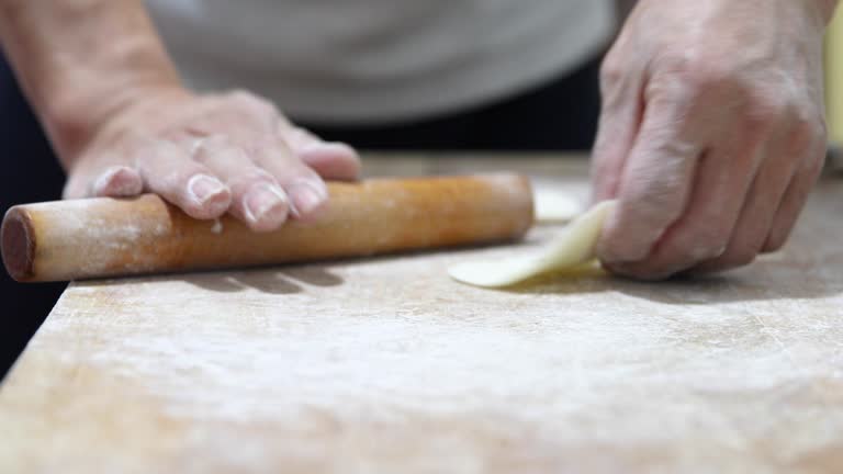 Rolling dough to make chinese dumplings