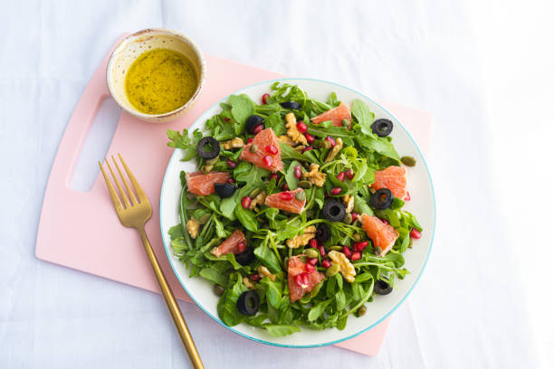 istock Rocket (arugula) and lamb's lettuce salad with grapefruit, pomegranate seeds, black olives, capers, walnuts, and mustard vinaigrette dressing 1690921582