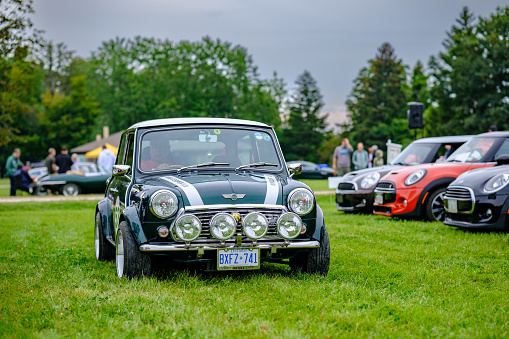 Oakville, Ontario, Canada- September 17, 2023.  MINI COOPER cars and fans on British Car Day show  in public park in suburb of Toronto, Canada. British Car Day is the largest British car show in North America. Over 1000 cars on display and 50 vendors. Held the 3rd Sunday of September at Bronte Park, Oakville, Ontario. Mini car has been around since 1959 and has been owned and issued by various car manufacturers.