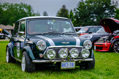 Oakville, Ontario, Canada- September 17, 2023.  MINI COOPER cars and fans on British Car Day show  in public park in suburb of Toronto, Canada. British Car Day is the largest British car show in North America. Over 1000 cars on display and 50 vendors. Held the 3rd Sunday of September at Bronte Park, Oakville, Ontario. Mini car has been around since 1959 and has been owned and issued by various car manufacturers.