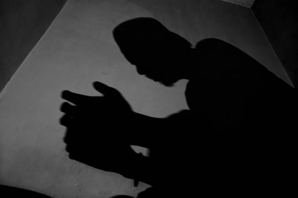 Shadow of a Muslim man praying. Shadow on the wall of muslim man praying during prayer, muslim or islam man sitting praying. i love allah in arabic silhouettes stock pictures, royalty-free photos & images
