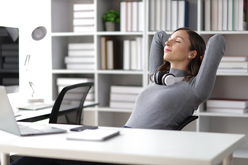 Woman doing stretching pose to relax in office.