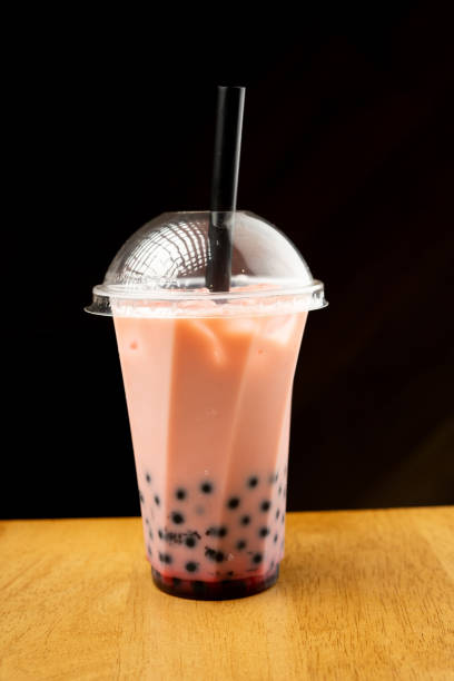 istock Bubble Tea in a plastic cup with drink straw on black background. Takeaway drinks concept. 1690930826