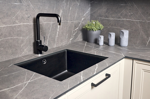 Single handle water kitchen faucet built in compact high pressure laminate HPL countertop. Kitchen undermount installation, granite composite sink.