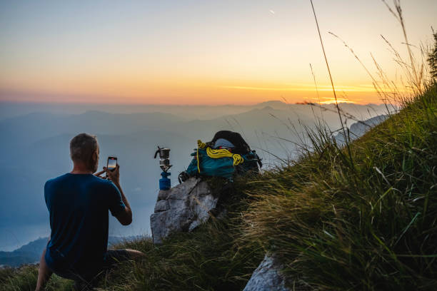istock hiker in high mountains taking a video clip 1690931795