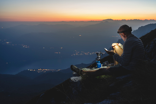 Hiker texting with smartphone during the night in the high mountains