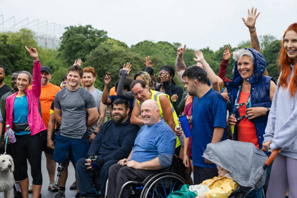 Excited to Start the Run! Group of run participants taking part in a fun run in Leazes Park in Newcastle upon Tyne in the North East of England. They are ready to run in the rain along the lakeside. The race is open to people of all ages and abilities and is also dog friendly. sports team event stock pictures, royalty-free photos & images