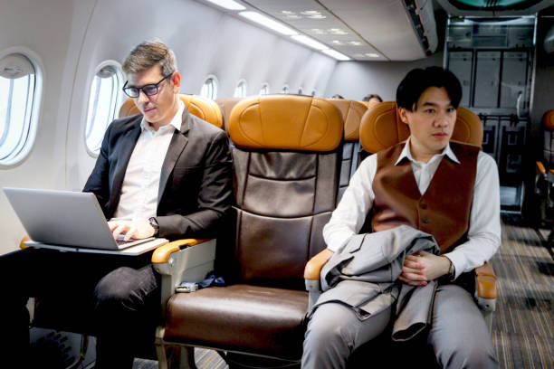istock Busy businessman working on laptop computer during sitting in comfortable seat inside airplane, male passenger working in aircraft cabin during business trip, traveling with airline transportation. 1690936583