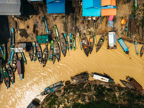 Stilt houses and fishing boats in Kampong Phluk, a floating village near Siem Reap, Cambodia. Aerial drone view.