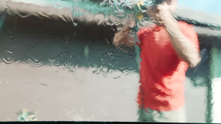 Male washing his car in the backyard.