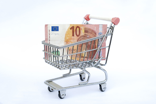 Euro paper currency 10 banknote money Shopping trolley cart on white background. Copy space for your text. Online shopping, buy mall market shop consumer concept. Small toy