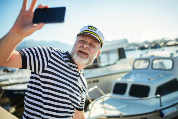 istock Mature man standing near the sea using smart phone 1690948243