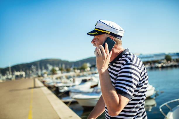 istock Mature man standing near the sea using smart phone 1690948248